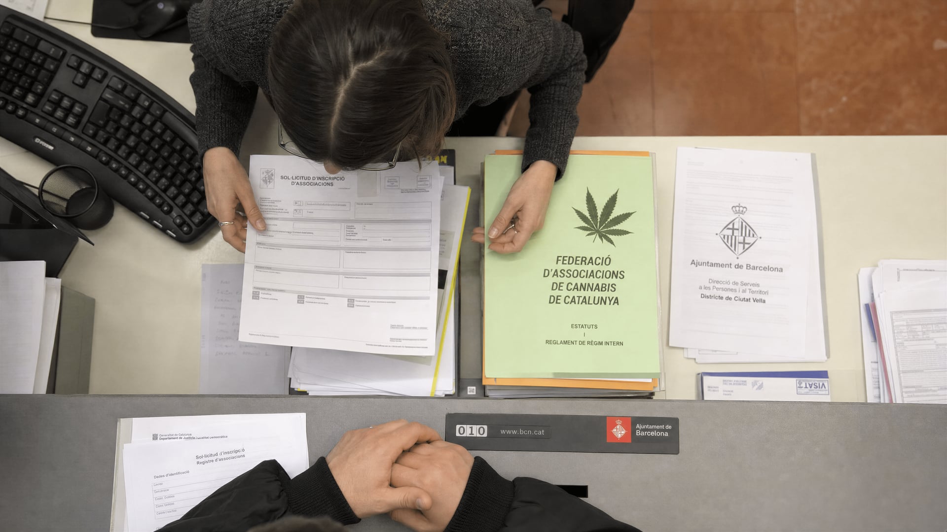 أوراق تسجيل جمعيات القنّب في برشلونة مرتبة على مكتب سجل مدني