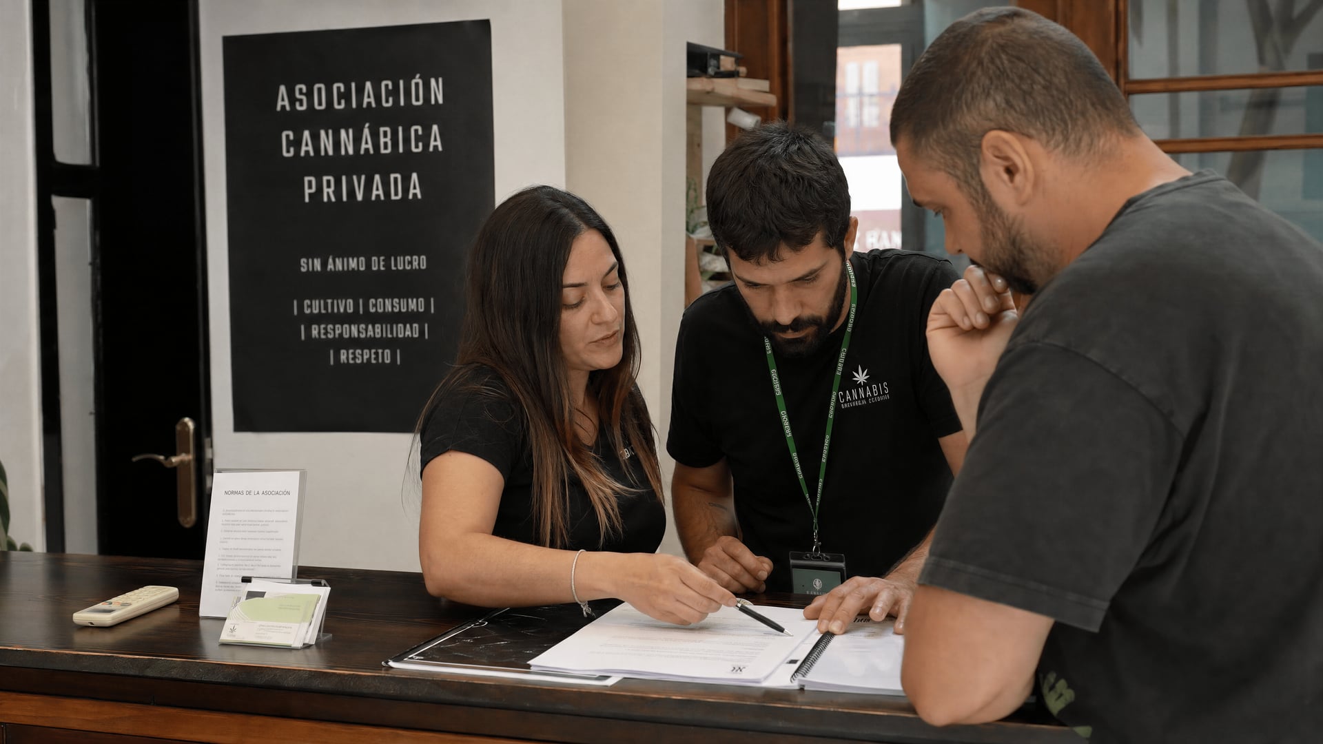 أعضاء يراجعون النظام الأساسي للجمعية واستمارات التسجيل عند مكتب استقبال نادٍ إسباني خاص